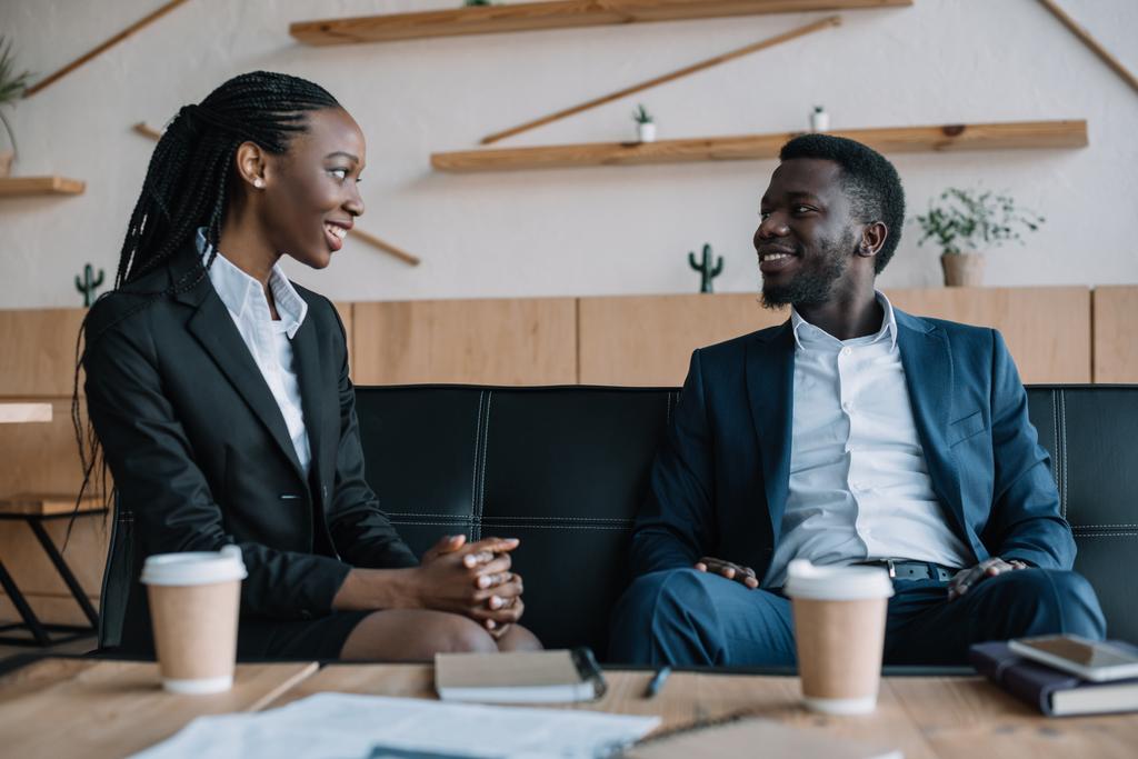 retrato de socios de negocios afroamericanos sonrientes mirándose en la cafetería
 - Foto, Imagen