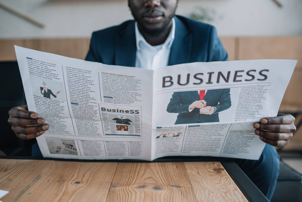 Μερική άποψη της Αφρικανικός Αμερικανός επιχειρηματίας με την εφημερίδα στο καφενείο - Φωτογραφία, εικόνα