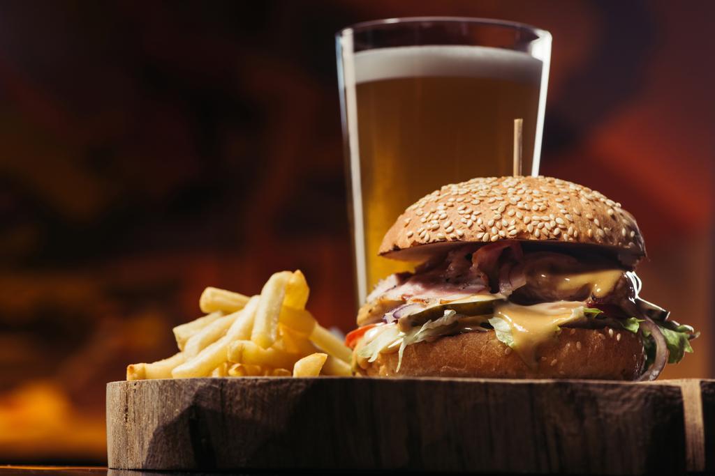 vista de cerca de sabrosa hamburguesa con pavo, papas fritas y vaso de cerveza
 - Foto, Imagen