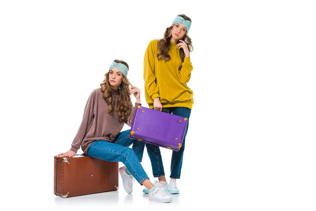 atractivos gemelos de estilo retro con maletas de viaje aisladas en blanco
 - Foto, imagen