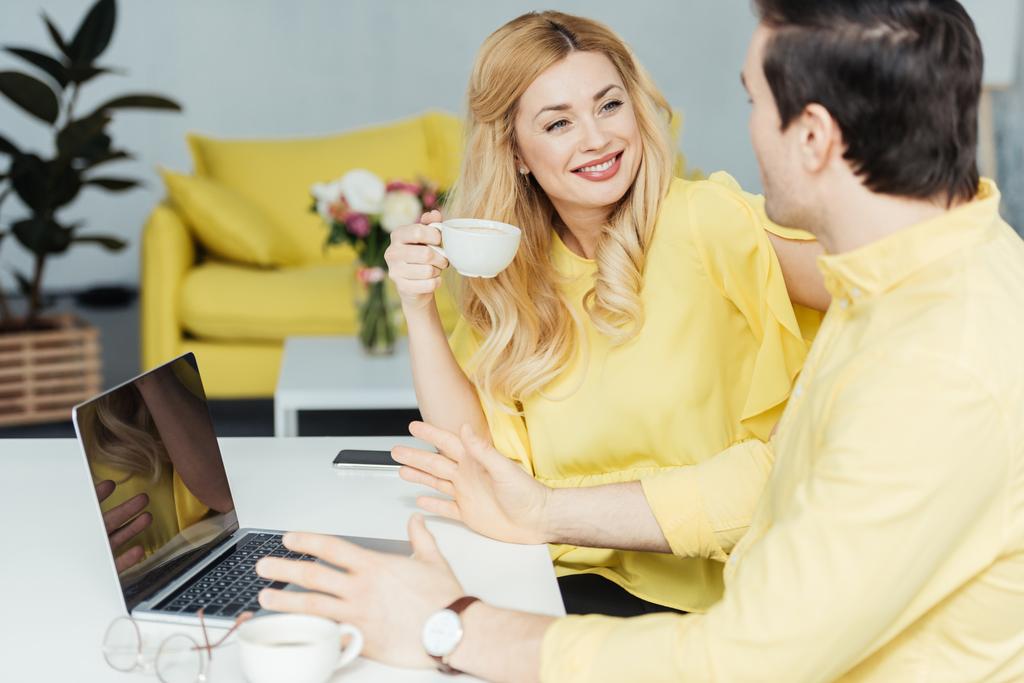 Férfi és nő, kávét iszik, és dolgozik a laptop konyha - Fotó, kép