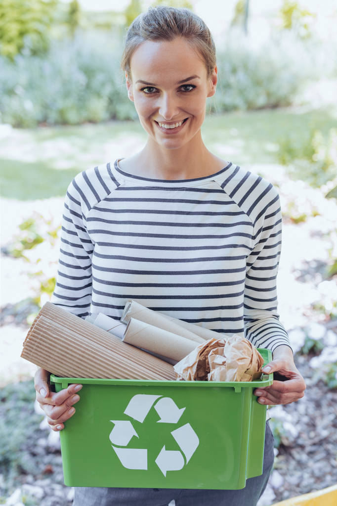 Mujer sonriente sosteniendo la papelera verde
 - Foto, Imagen