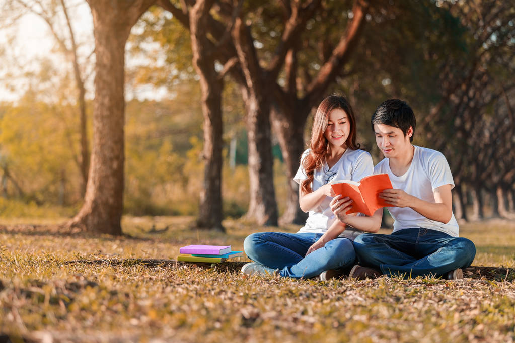 férfi és nő ült, és Olvasson egy könyvet park - Fotó, kép