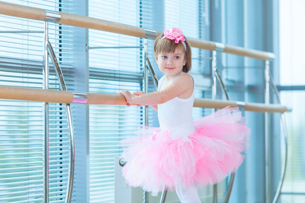 kleines Ballerina-Mädchen in einem rosa Tutu. entzückendes Kind, das klassisches Ballett in einem weißen Studio tanzt. Kinder tanzen. Kinder, die auftreten. junge begabte Tänzerin in einer Klasse. Vorschulkind nimmt Kunstunterricht. - Foto, Bild