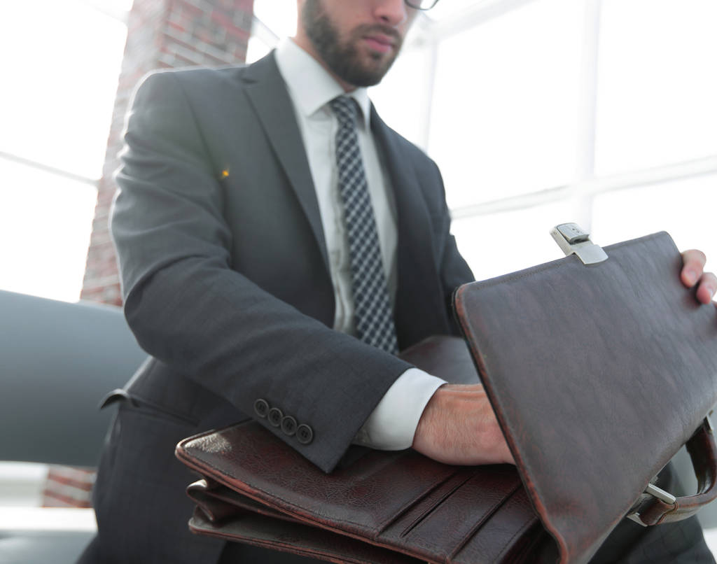 businessmans hand met suitecase in een modern kantoor - Foto, afbeelding