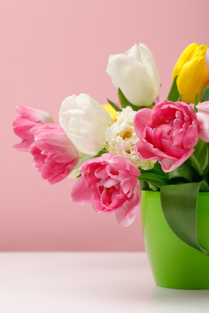 Pályázati virágzó tulipánok a vázában, rózsaszín háttérrel - Fotó, kép