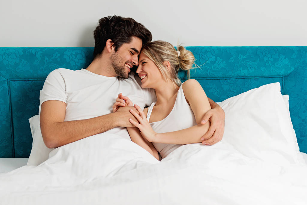 Młoda kochająca się para leżąca na łóżku, ciesząca się - Zdjęcie, obraz