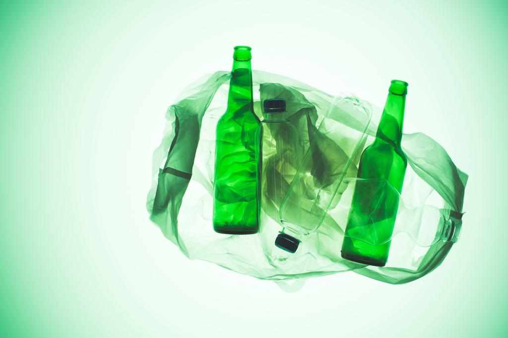 transparante plastic zak met verschillende flessen onder groen licht getinte - Foto, afbeelding