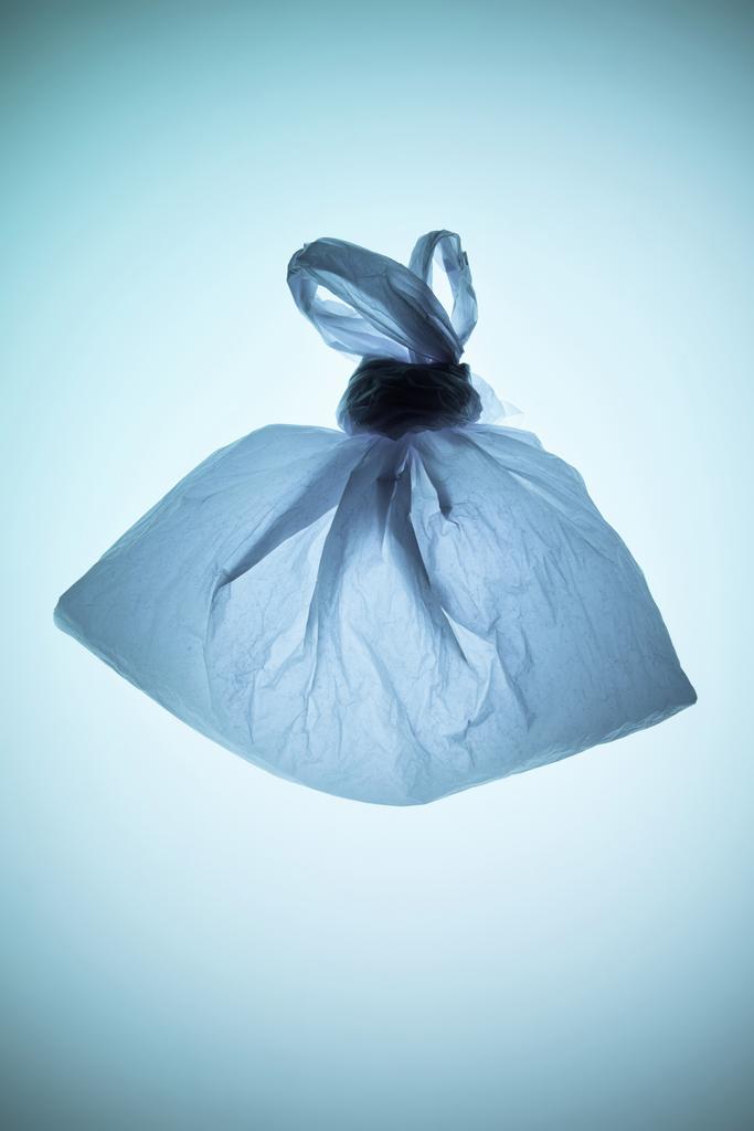 tied transparent plastic bag under blue toned light - Photo, Image