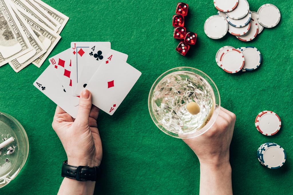 Vrouw met alcohol in glas poker spel door casino tafel - Foto, afbeelding