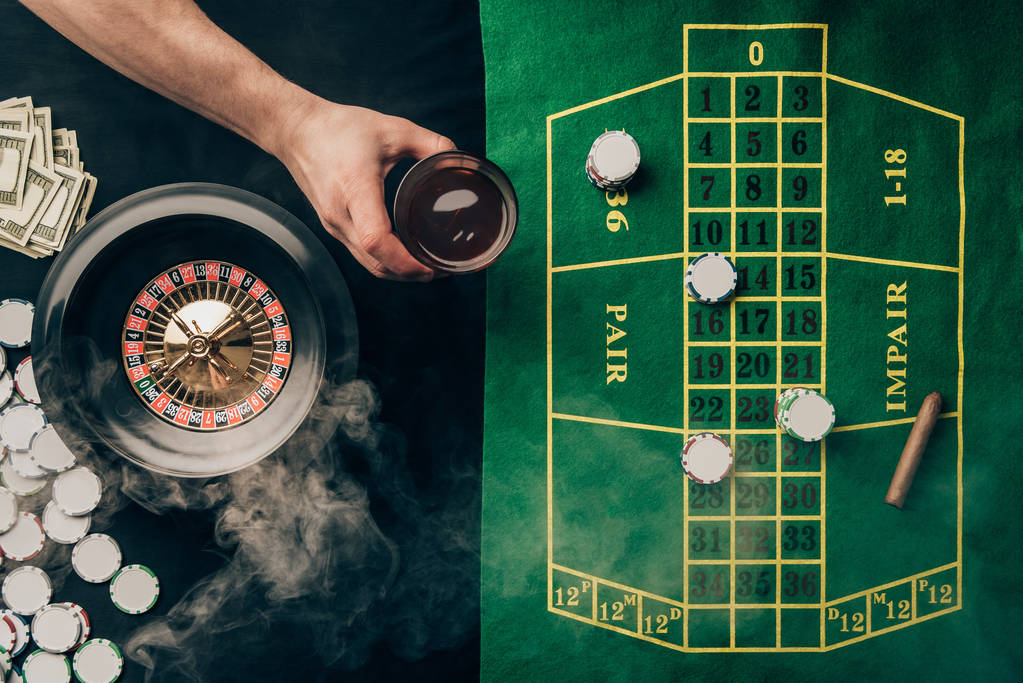 Bahisler ve rulet casino masasının bardakta viski eliyle - Fotoğraf, Görsel
