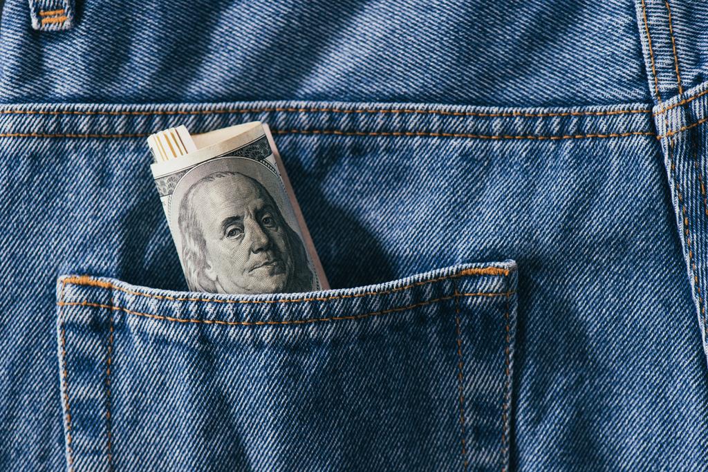 vista de cerca del rollo de billetes de dólar en el bolsillo de los jeans
 - Foto, imagen