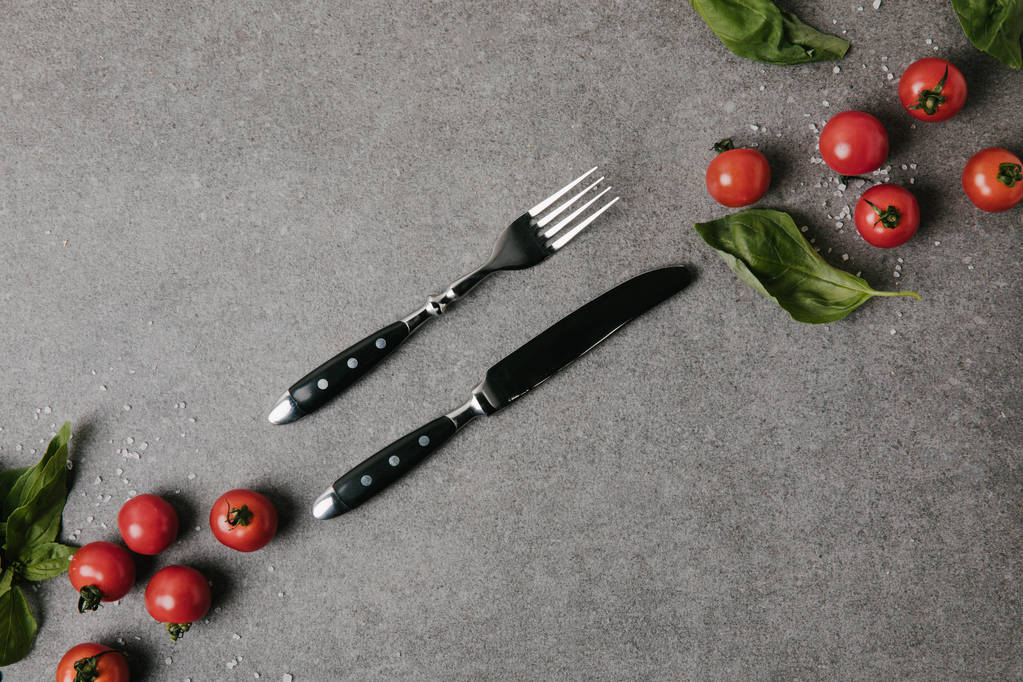 pohled shora na čerstvá rajčata, bazalka a sůl s příbory Grey  - Fotografie, Obrázek