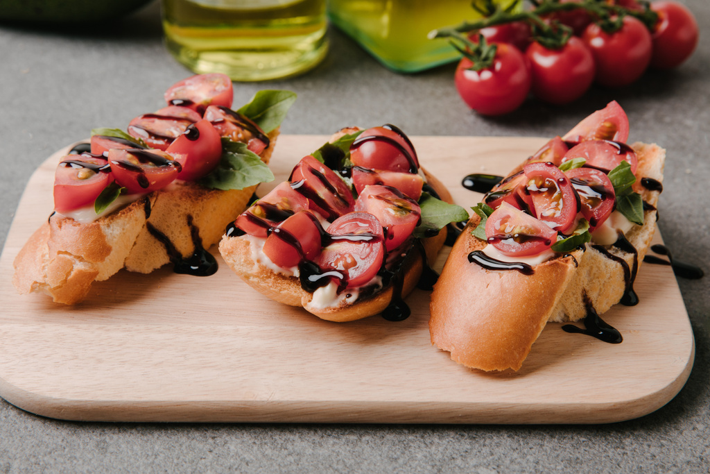 食材で木の板に美味しいブルスケッタ トマトとバルサミコのクローズ アップ ビュー   - 写真・画像