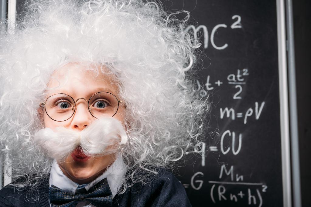 weinig Einstein in brillen met theorie van relativiteit op schoolbord - Foto, afbeelding