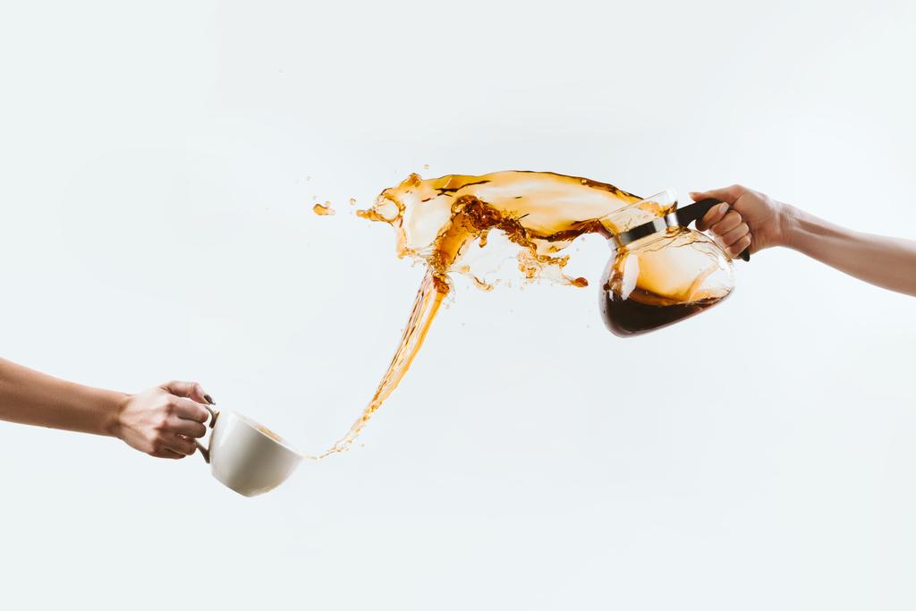 oříznutý pohled rukou šplouchání aromatickou kávu z poháru a sklo hrnec, izolované na bílém - Fotografie, Obrázek