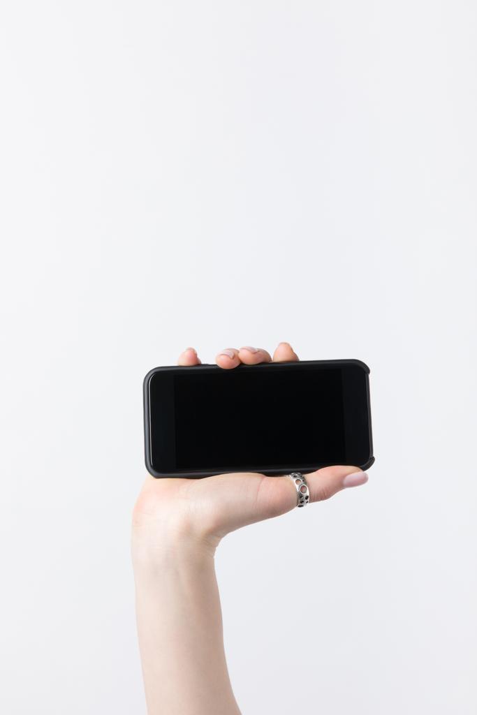 recortado de mujer sosteniendo teléfono inteligente con pantalla lank aislado en blanco
 - Foto, imagen