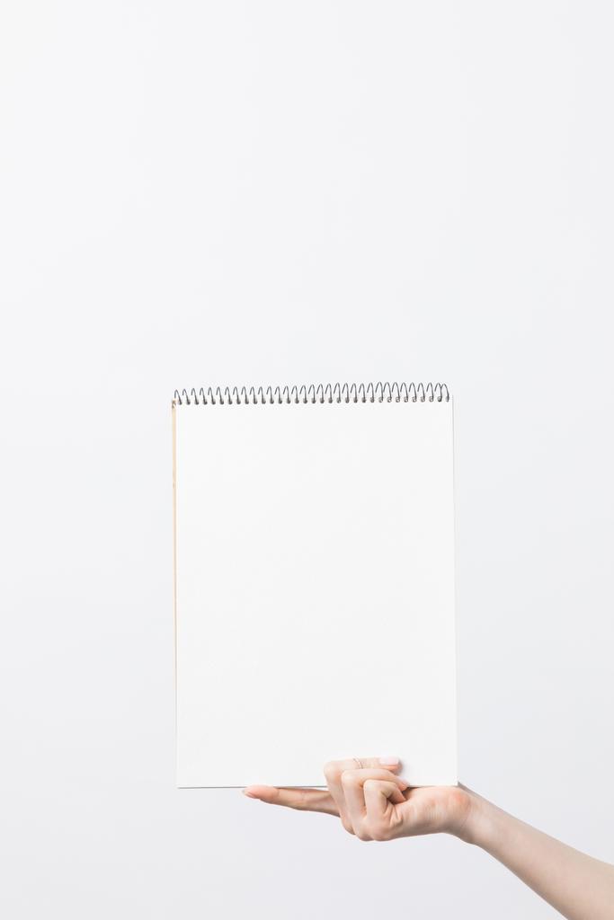 partial view of woman holding blank sketchbook in hand isolated on white - Photo, Image