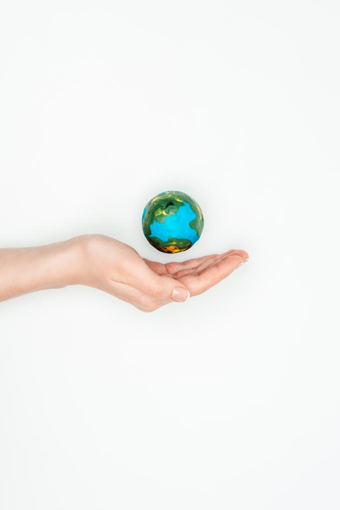 обрезанный образ женщины, держащейся за руку рядом с землей модель изолированы на белом, Земля день концепции
 - Фото, изображение