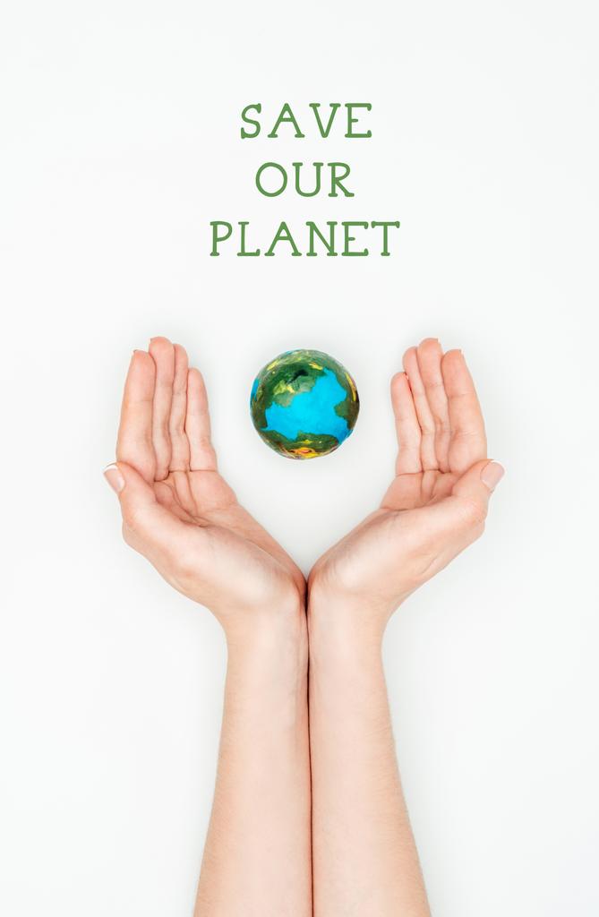 bijgesneden afbeelding van vrouw met aarde model met teken redden onze planeet geïsoleerd op wit, aarde dag concept - Foto, afbeelding