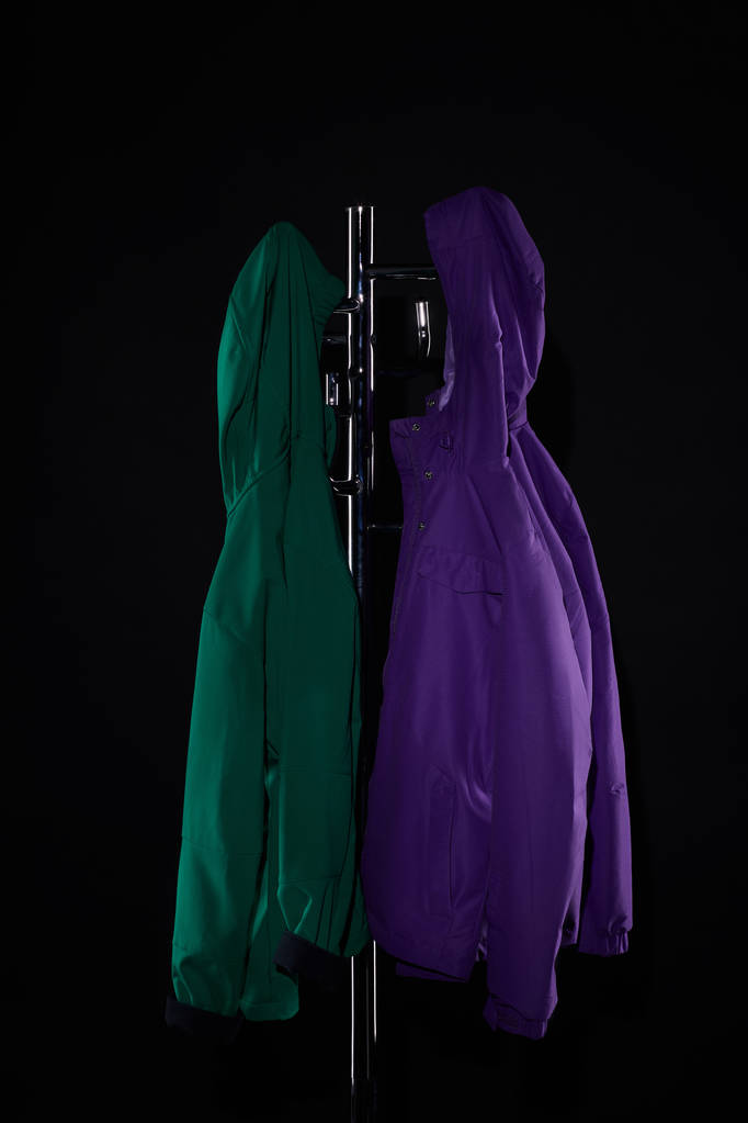 imperméables suspendus sur porte-manteau isolé sur noir
 - Photo, image