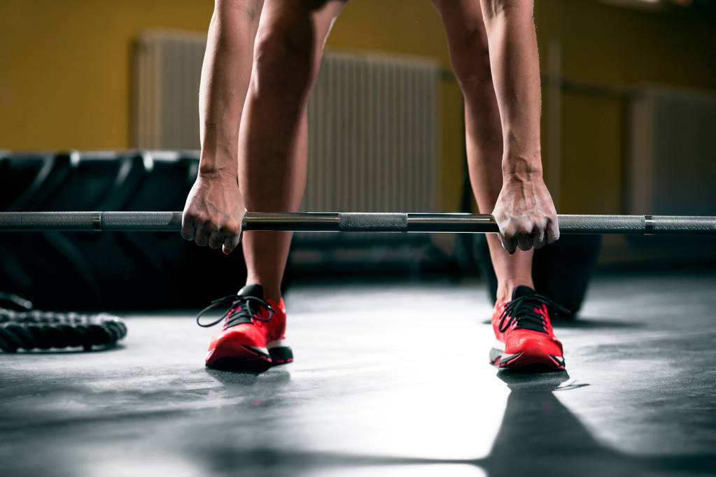 Entrenamiento de mujer con barra de pesas en el gimnasio, prepararse para levantar pesas de cerca
 - Foto, Imagen
