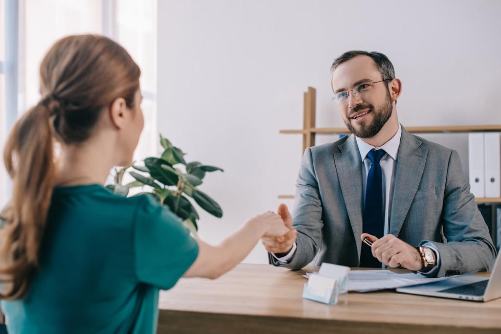 частичный взгляд бизнесмена и клиента на рукопожатие во время встречи в офисе
 - Фото, изображение
