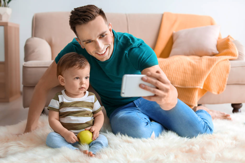 Νεαρός πατέρας με χαριτωμένο μικρό γιο λήψη selfie στο σπίτι - Φωτογραφία, εικόνα