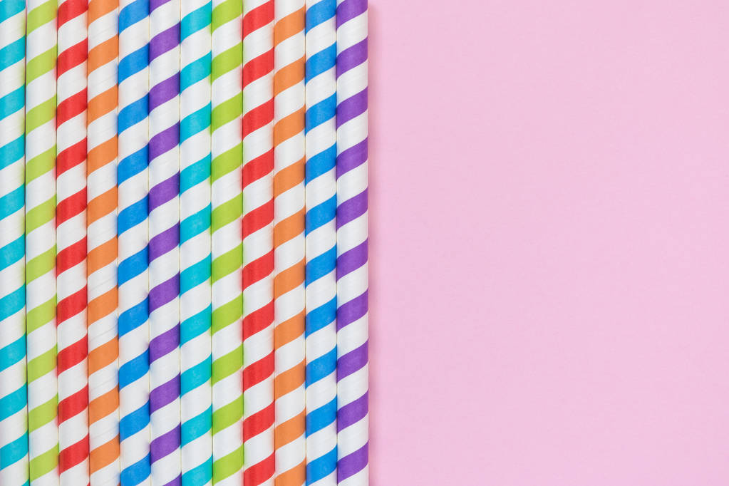 Multicolored drinking paper straws against rose background minimalistic concept - Photo, Image