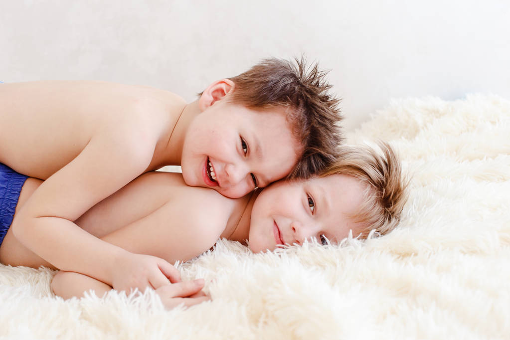 dos chicos se acuestan en la cama y se ríen
 - Foto, imagen