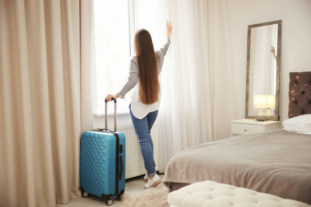 Młoda kobieta z bagażem w pokoju hotelowym - Zdjęcie, obraz