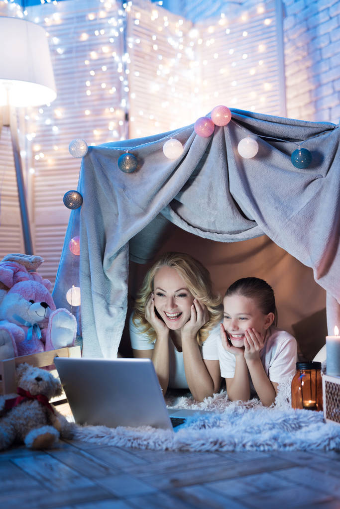 Grandmother and granddaughter watching movie on laptop in cozy blanket house at home - Photo, Image