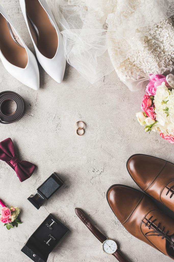 bovenaanzicht van bruiloft accessoires en ringen op grijs tafelblad - Foto, afbeelding