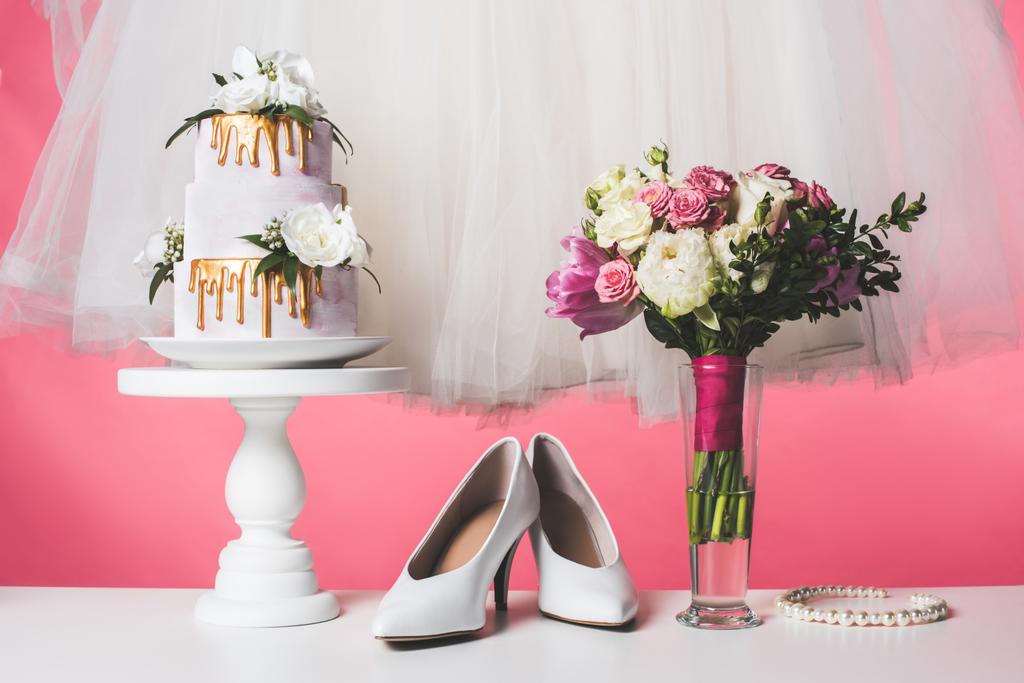gâteau de mariage sur support de gâteau avec robe blanche et bouquet isolé sur rose
 - Photo, image