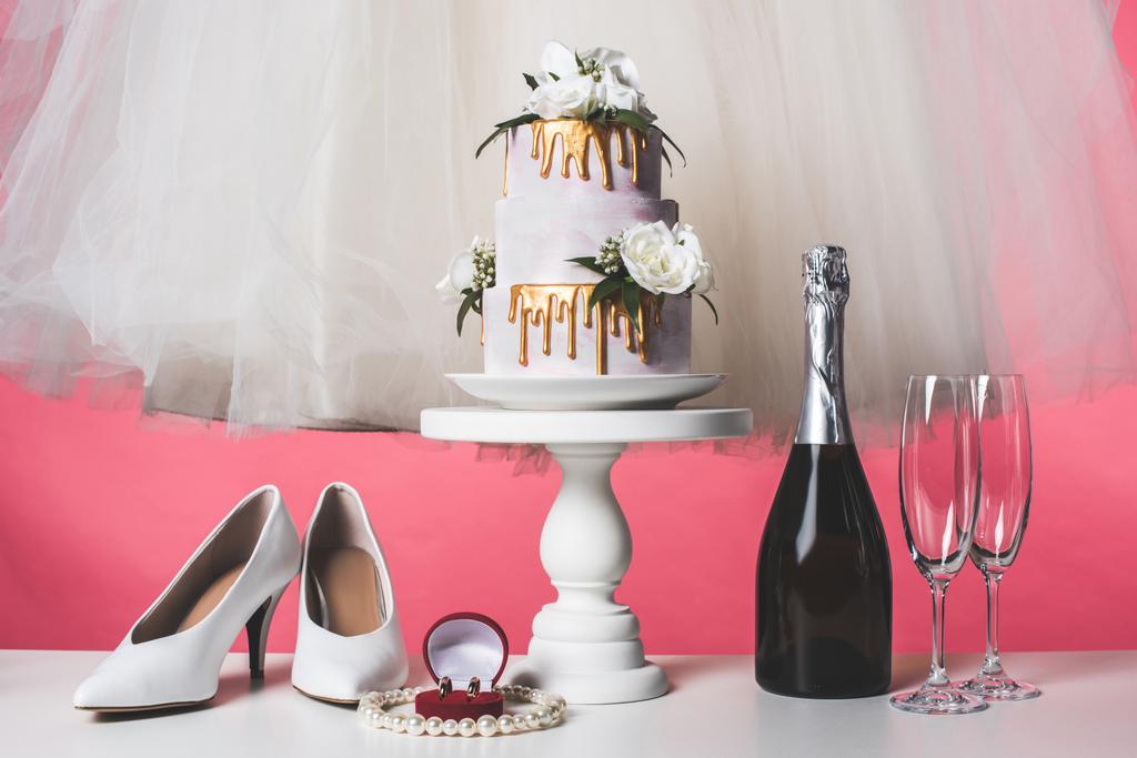 pair of shoes, wedding cake and champagne isolated on pink - Photo, Image