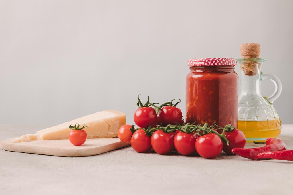 kirsikkatomaatit juustolla, ketsupilla ja oliiviöljyllä betonipöydällä, italialaisen keittiön ainesosat
 - Valokuva, kuva