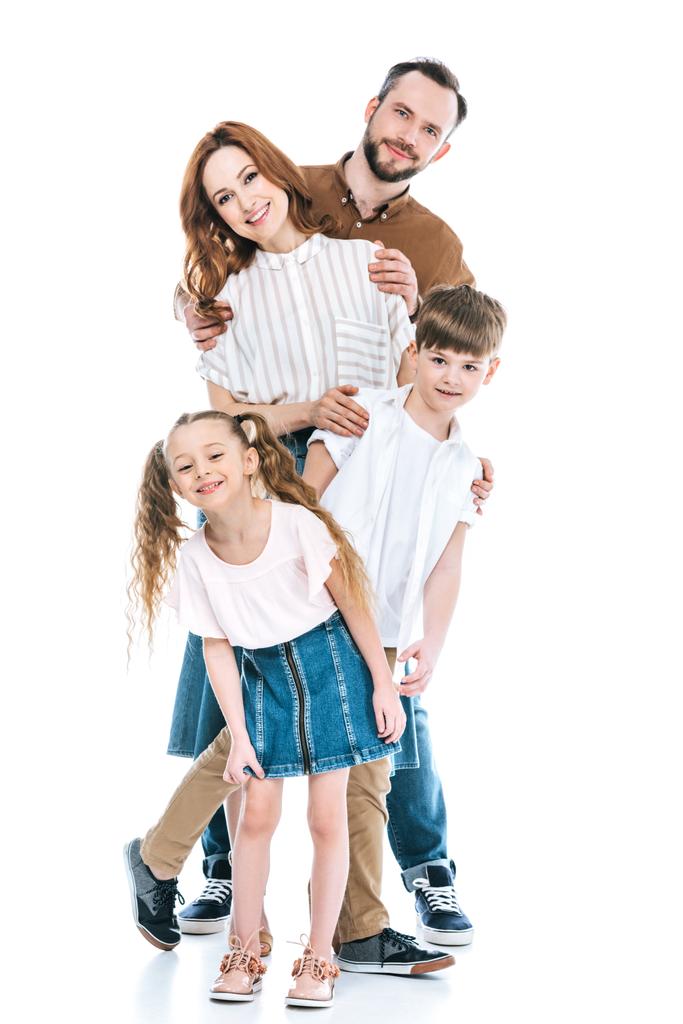 vrolijke gezin met twee kinderen permanent samen en lachend op camera geïsoleerd op wit - Foto, afbeelding