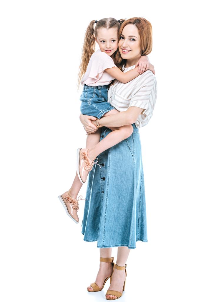 щаслива мати, що носить чарівну маленьку доньку і посміхається на камеру ізольовано на білому
 - Фото, зображення