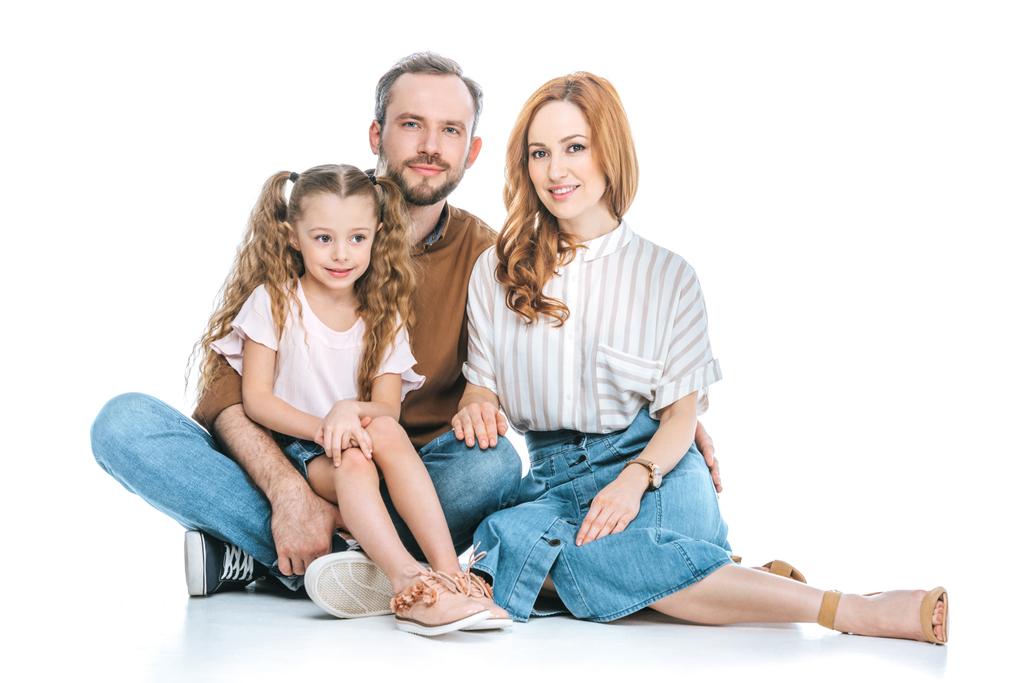 famille heureuse avec un enfant assis ensemble et souriant à la caméra isolé sur blanc
 - Photo, image
