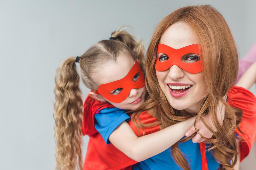 楽しんで一緒に灰色に分離されたスーパー ヒーロー衣装で幸せな母と娘 - 写真・画像
