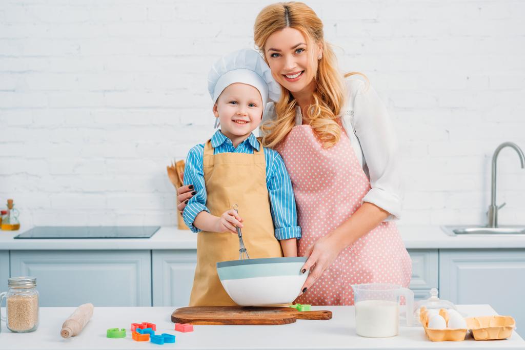 Smiling mother and son in kitchen cooking together - Photo, Image