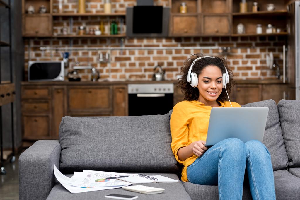atractiva joven mujer que trabaja con el ordenador portátil y escuchar música en casa
 - Foto, imagen