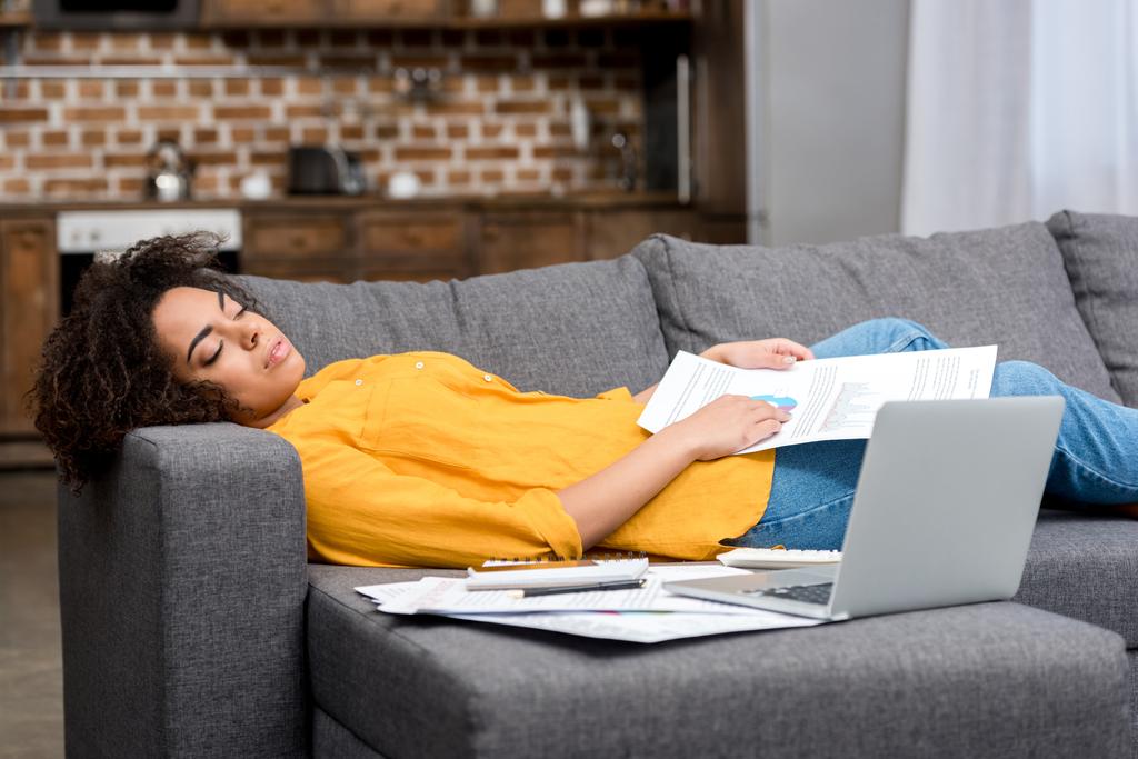 zmęczony african american kobieta śpi na kanapie po pracy w domu - Zdjęcie, obraz