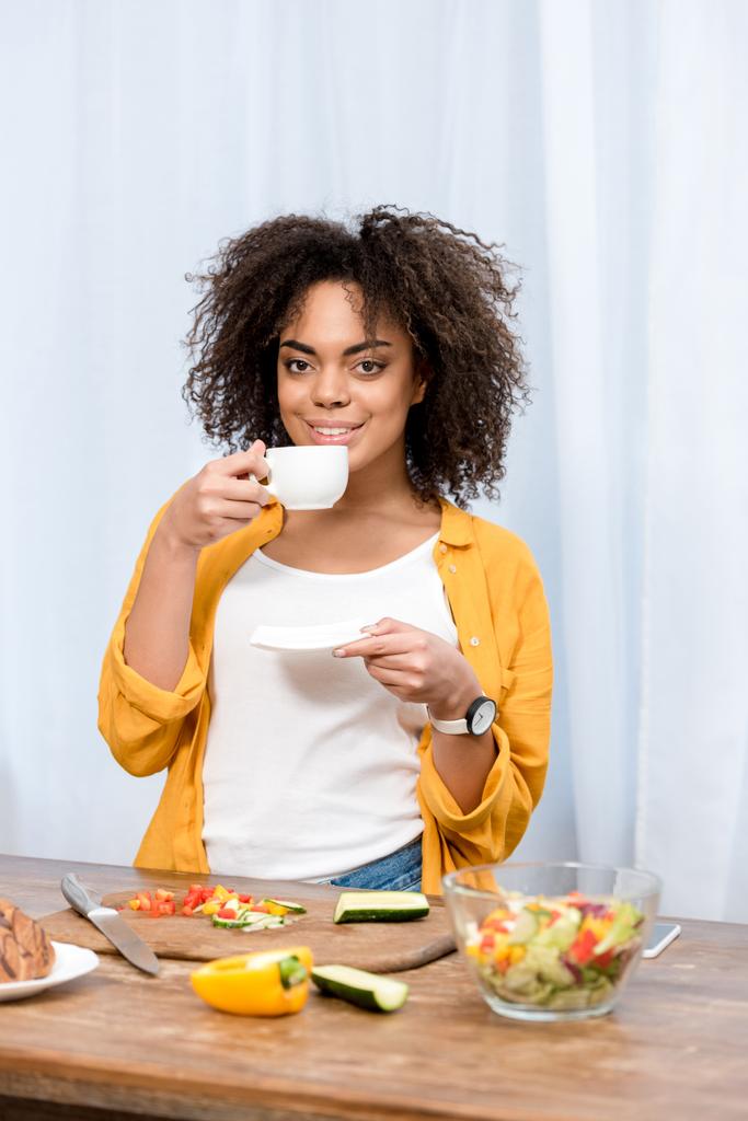 young  mixed race woman drinking coffee and taking diner at home - Photo, Image