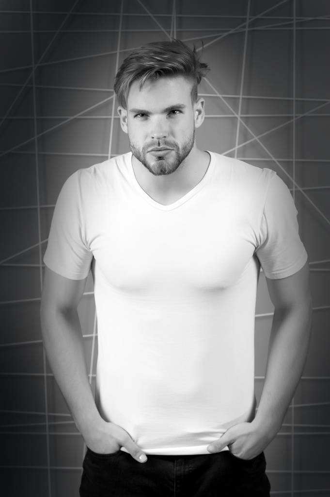 Knappe bebaarde man in lege witte tshirt met stijlvolle haar, zwart-wit - Foto, afbeelding