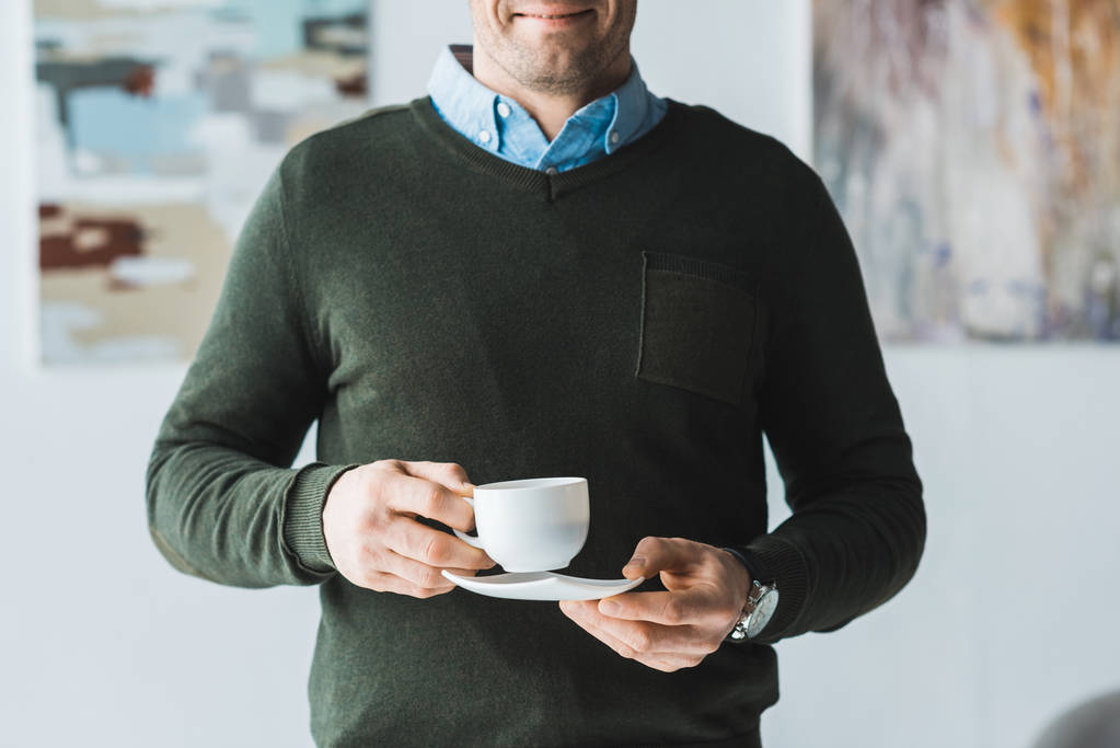 Lächelnder Mann mit einer Tasse Kaffee in der Hand - Foto, Bild