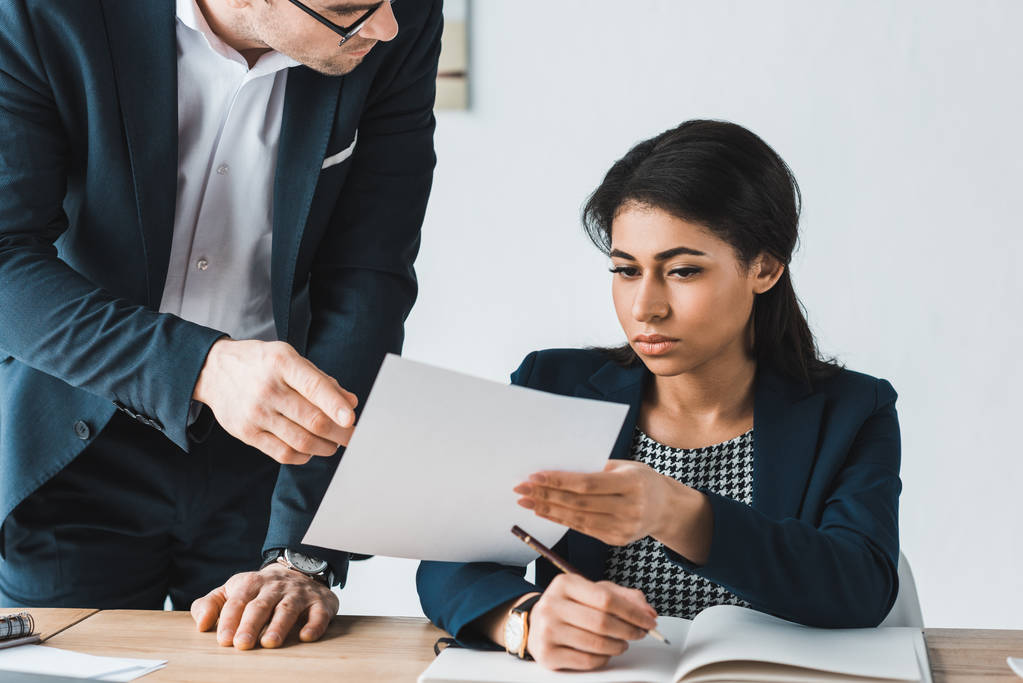 Бизнесмен и предпринимательница рассматривают документы по контракту в офисе
 - Фото, изображение