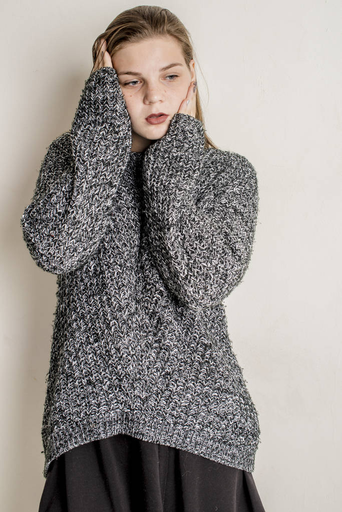 Jovem menina bonita sentada em um suéter quente longo cinza
 - Foto, Imagem