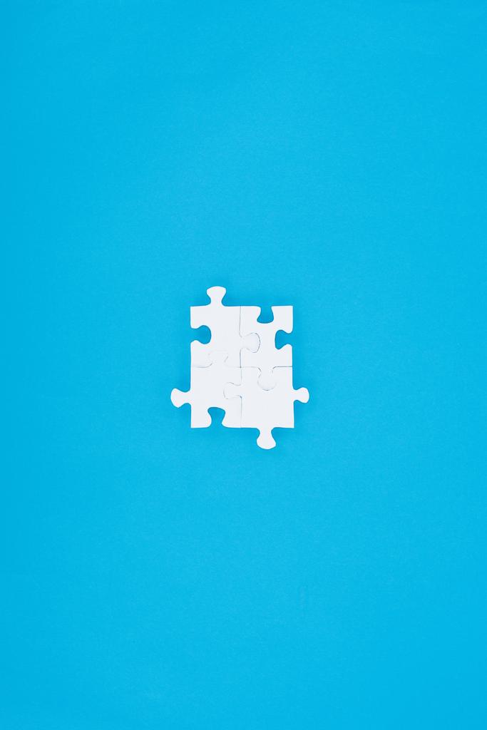 vue de dessus des puzzles blancs assemblés isolés sur bleu, concept d'entreprise
 - Photo, image