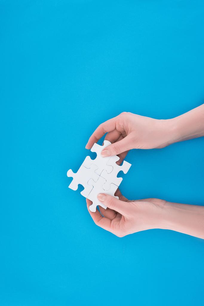 oříznutého obrazu podnikatelka drží sestavený puzzle izolované na modré, obchodní koncept - Fotografie, Obrázek